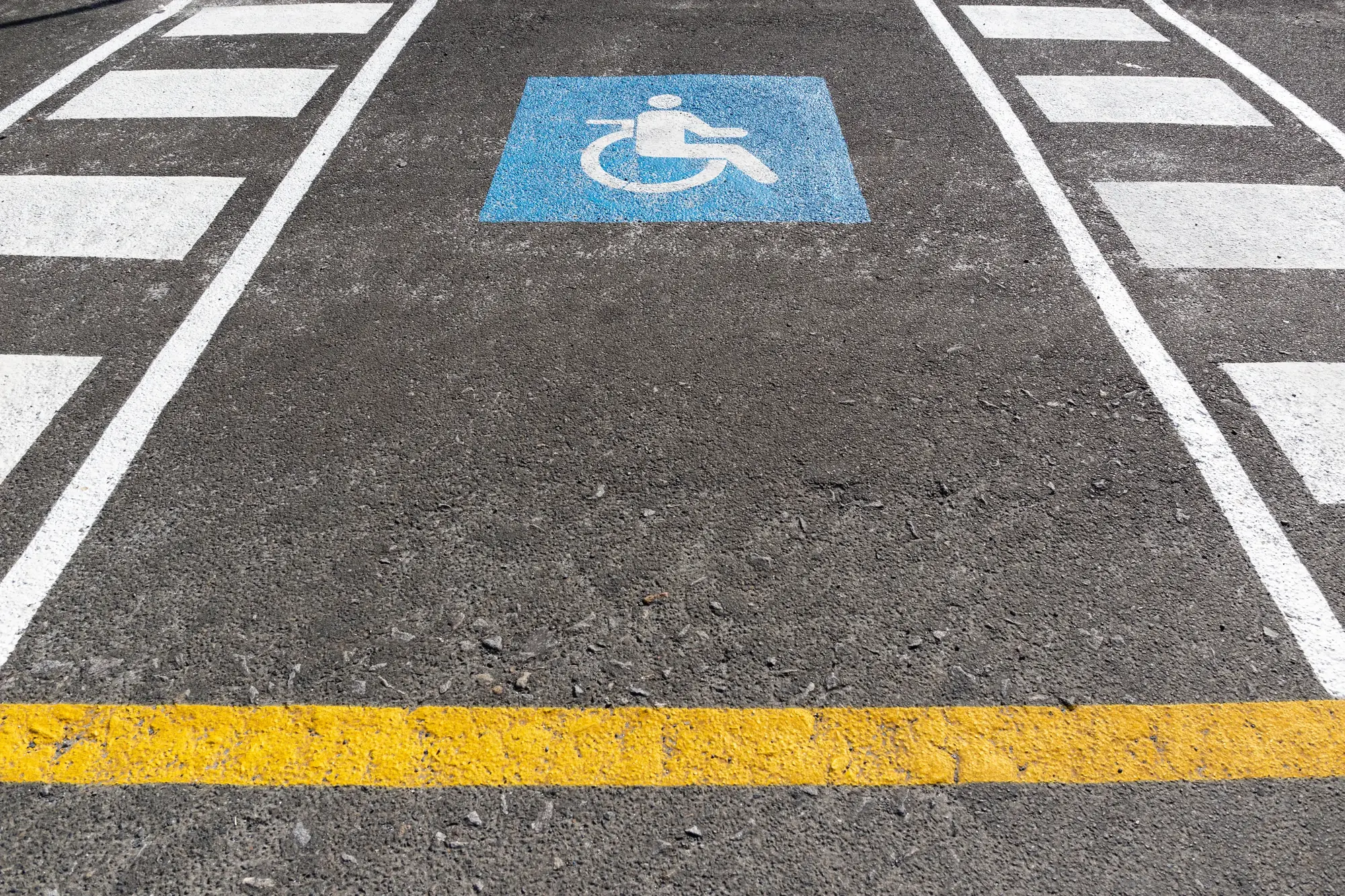 ADA-compliant accessible parking symbol freshly painted on asphalt
