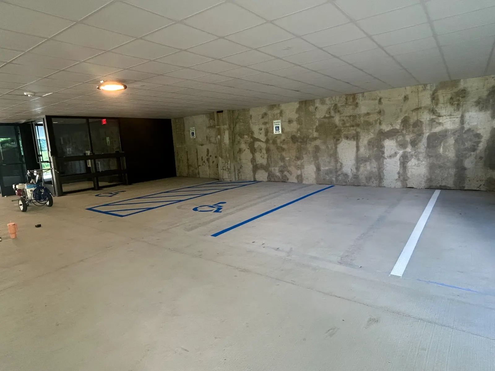 Parking garage with fresh blue ADA stalls striped by BAR Striping